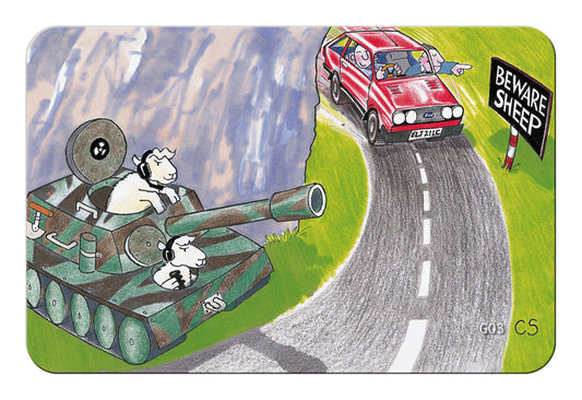 A rectangular illustrated mat or sign with rounded corners, showing a cartoon scene of a sheep in a green tank on a winding road, with a red car and a black 'Beware Sheep' sign nearby. The artwork fills most of the product area and is photographed against a plain white background.